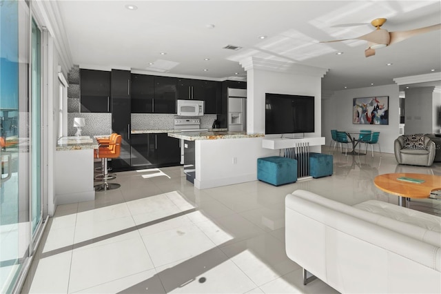 living room featuring light tile patterned flooring and decorative columns