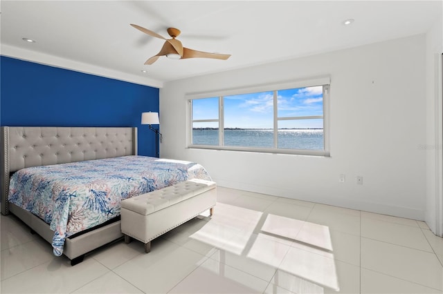 tiled bedroom with ceiling fan and a water view