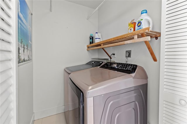 laundry room featuring washing machine and dryer and light tile patterned floors