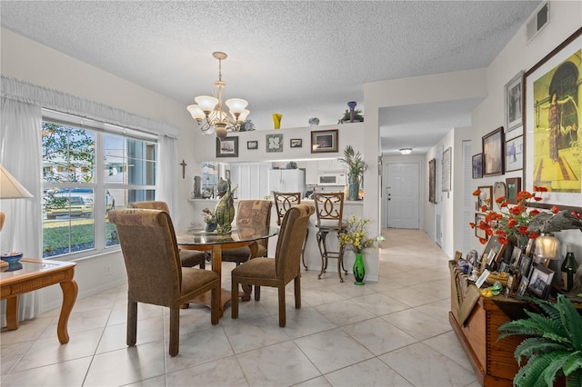 tiled dining area featuring a textured ceiling and a notable chandelier