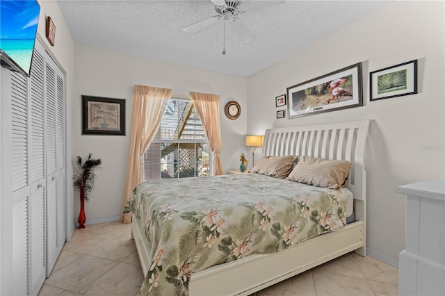 bedroom with light tile patterned floors, a textured ceiling, a closet, and ceiling fan