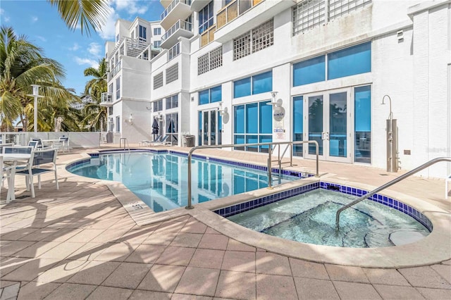 view of swimming pool featuring a community hot tub and a patio