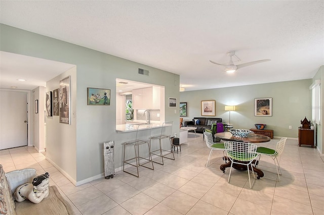 tiled dining space with ceiling fan