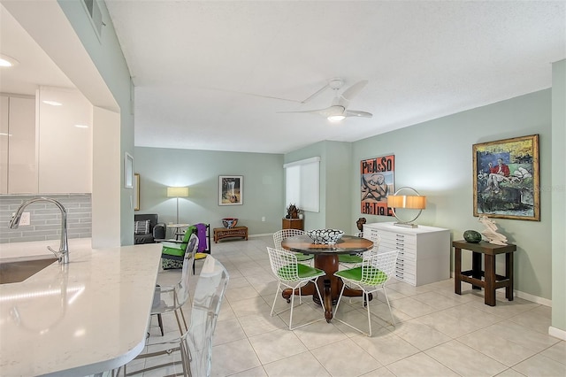 dining space with sink, ceiling fan, and light tile patterned flooring