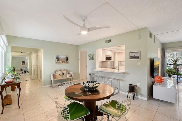 tiled dining area featuring ceiling fan