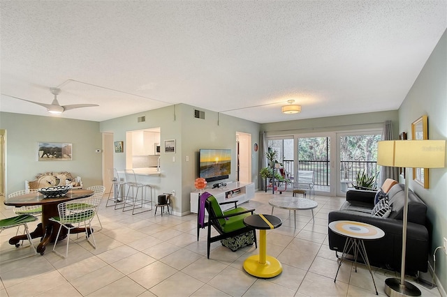 tiled living room featuring ceiling fan and a textured ceiling