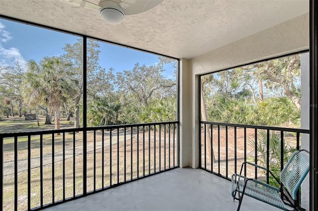 unfurnished sunroom featuring ceiling fan