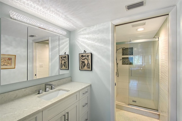 bathroom with vanity and a shower with shower door