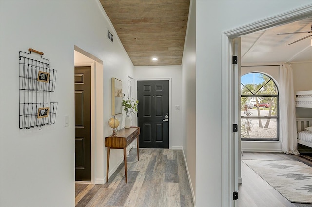 doorway featuring ceiling fan, wooden ceiling, and light wood-type flooring