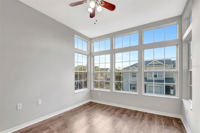 unfurnished sunroom featuring ceiling fan