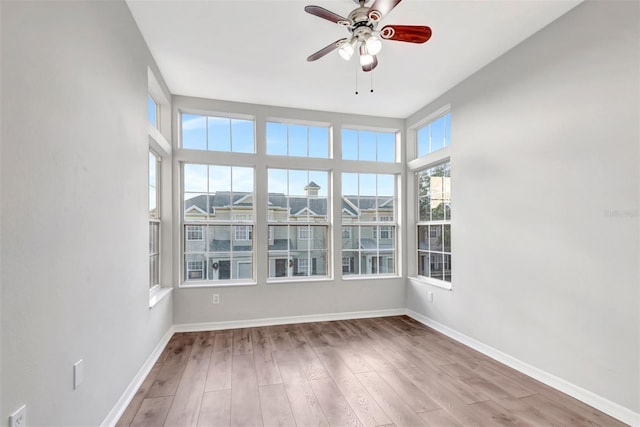 empty room featuring hardwood / wood-style flooring, plenty of natural light, and ceiling fan