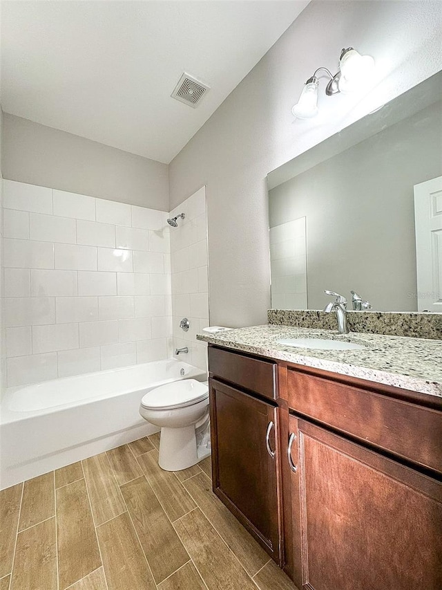 full bathroom with tiled shower / bath combo, vanity, and toilet