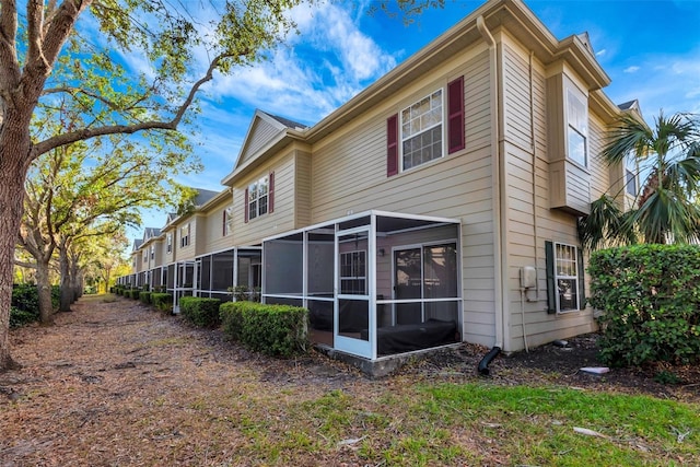 rear view of property featuring a sunroom