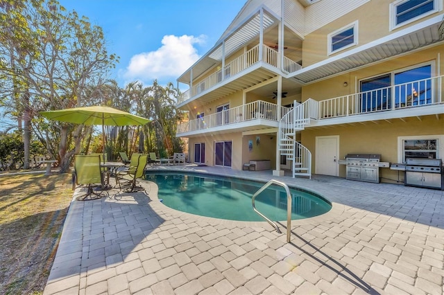 view of swimming pool with grilling area, a patio, and ceiling fan