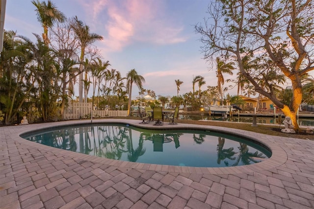 pool at dusk with a patio area