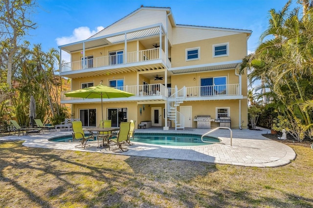 rear view of property with exterior kitchen, a patio, a balcony, and ceiling fan