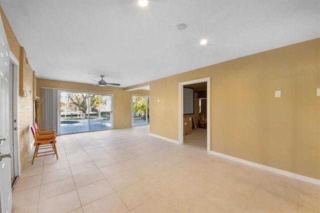 spare room with ceiling fan and light tile patterned floors