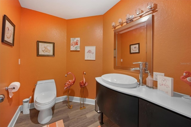 bathroom with vanity, hardwood / wood-style flooring, and toilet