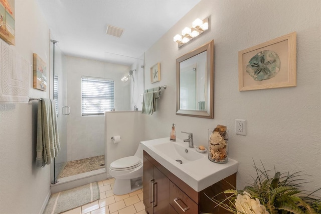 bathroom with tile patterned floors, vanity, toilet, and a shower with shower door