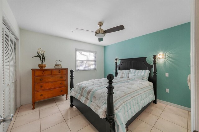 bedroom featuring light tile patterned floors, a closet, and ceiling fan