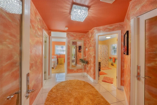 hallway featuring a wealth of natural light and light tile patterned floors