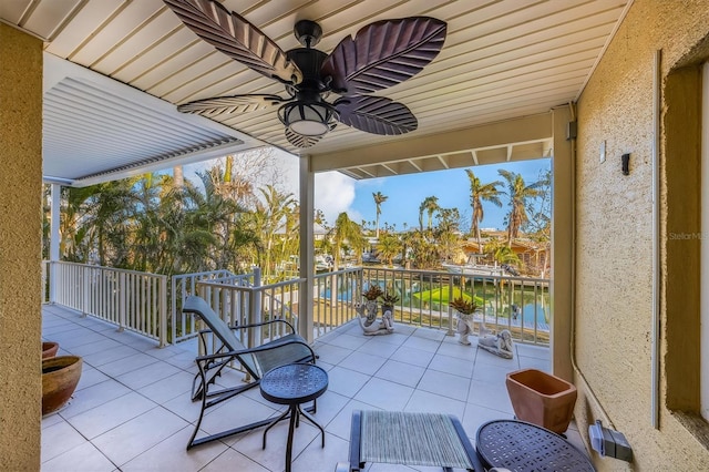 view of patio featuring a balcony, a water view, and ceiling fan