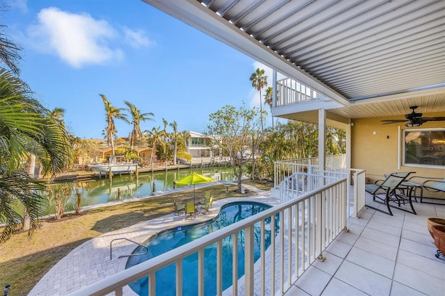 balcony with a water view, ceiling fan, and a patio area