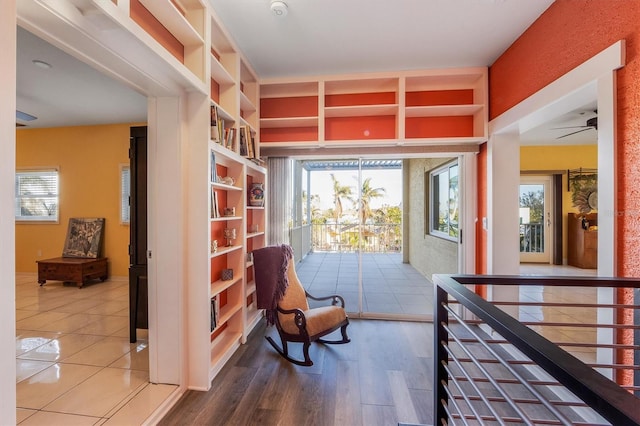 sitting room with hardwood / wood-style floors, built in shelves, and a wealth of natural light