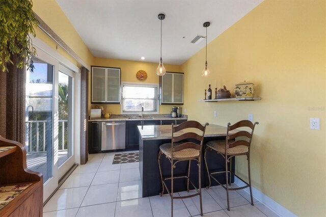 kitchen featuring pendant lighting, dishwasher, sink, a kitchen bar, and kitchen peninsula