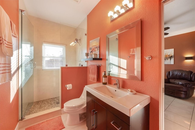 bathroom featuring vanity, a shower with shower door, tile patterned floors, and toilet