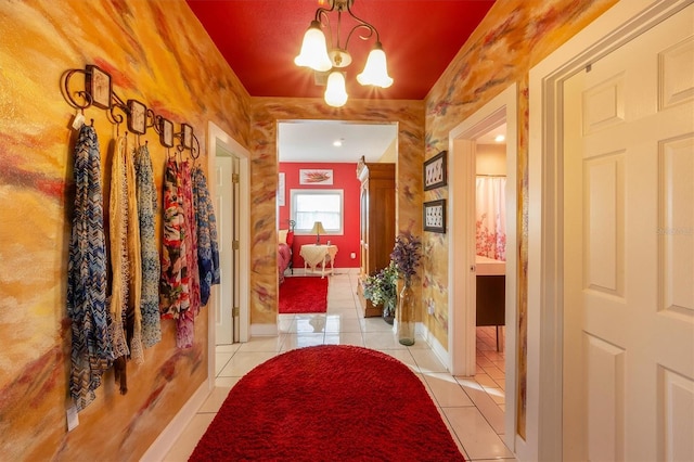 hallway featuring light tile patterned floors and a chandelier