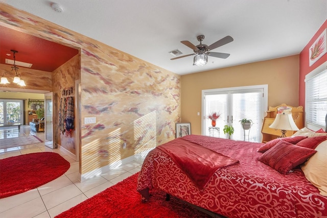 bedroom featuring light tile patterned flooring, access to exterior, ceiling fan with notable chandelier, and multiple windows