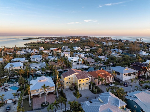 aerial view at dusk featuring a water view