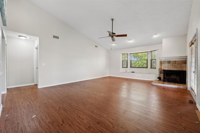 unfurnished living room featuring a tile fireplace, high vaulted ceiling, dark wood-type flooring, and ceiling fan