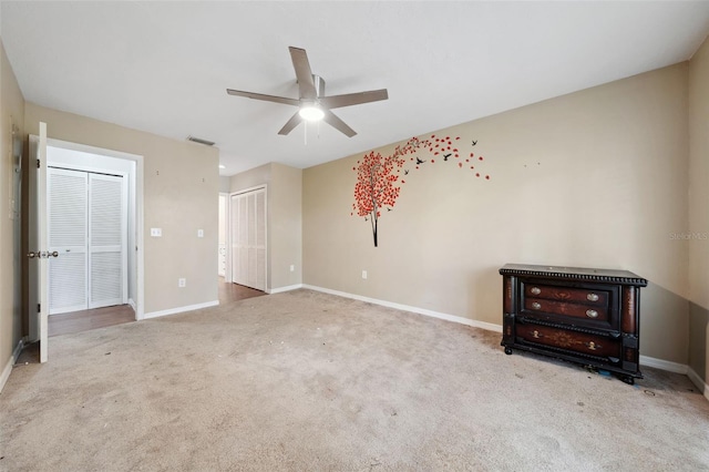 interior space with ceiling fan and carpet flooring