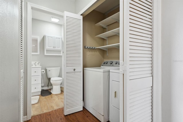 washroom with dark wood-type flooring and washer and clothes dryer