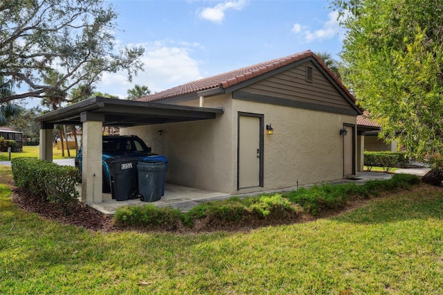 view of home's exterior with a yard and a carport