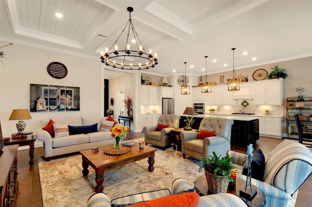 living room featuring beamed ceiling, wood-type flooring, sink, a chandelier, and crown molding