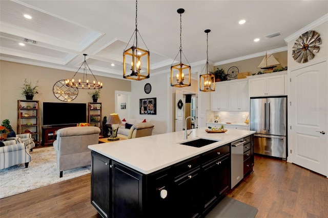 kitchen featuring sink, white cabinetry, hanging light fixtures, stainless steel appliances, and an island with sink