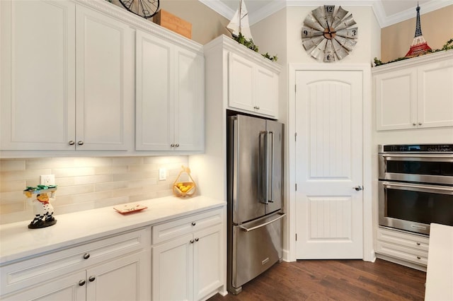 kitchen with ornamental molding, dark hardwood / wood-style flooring, stainless steel appliances, decorative backsplash, and white cabinets