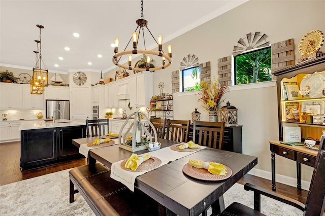 dining area featuring crown molding, dark hardwood / wood-style flooring, sink, and a notable chandelier