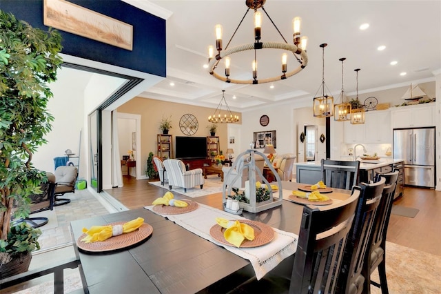 dining space with crown molding, a chandelier, and light wood-type flooring