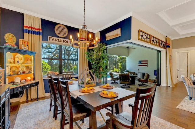 dining space with crown molding, ceiling fan with notable chandelier, and hardwood / wood-style floors