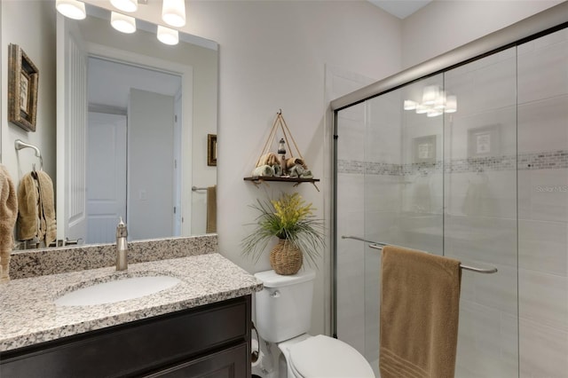 bathroom with vanity, toilet, and an enclosed shower