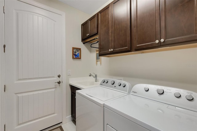 washroom with cabinets, sink, and washer and clothes dryer