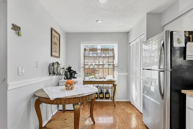 dining room featuring light hardwood / wood-style floors and a textured ceiling