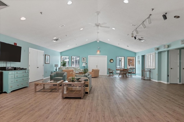 living room with lofted ceiling, a textured ceiling, ceiling fan, and light wood-type flooring