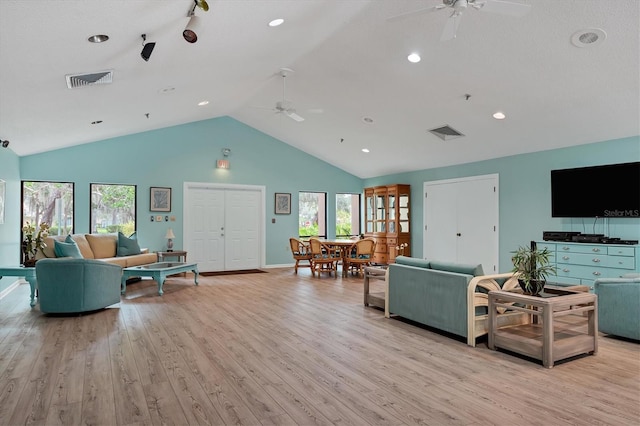 living room with ceiling fan, vaulted ceiling, and light hardwood / wood-style flooring