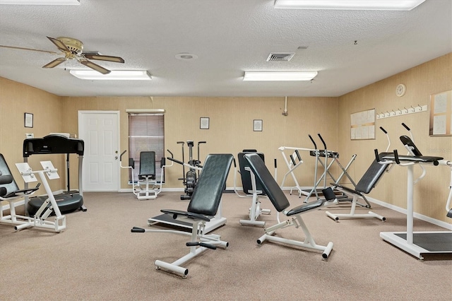 workout area featuring ceiling fan and a textured ceiling