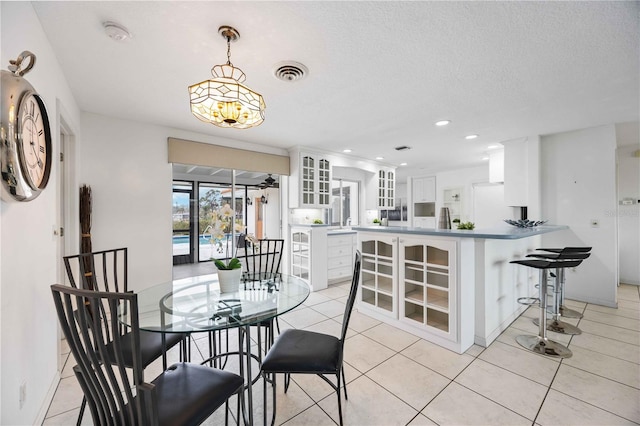 dining space with a textured ceiling and light tile patterned floors